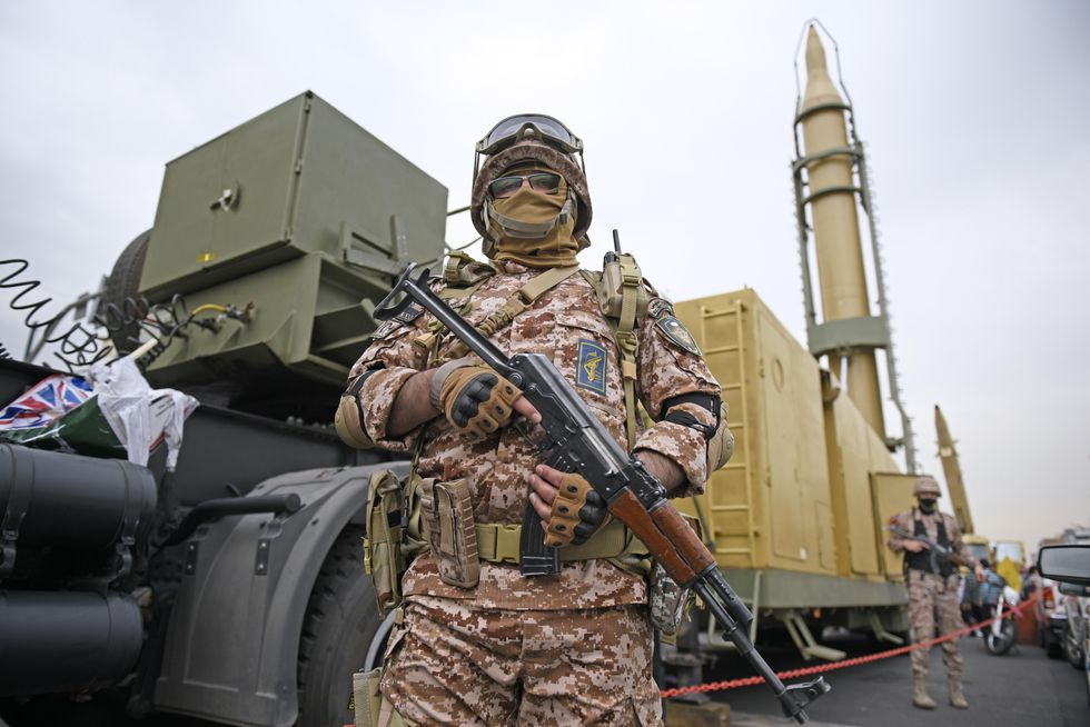 A member of the Revolutionary Guard stands in front of Shahab-3 missile in Tehran