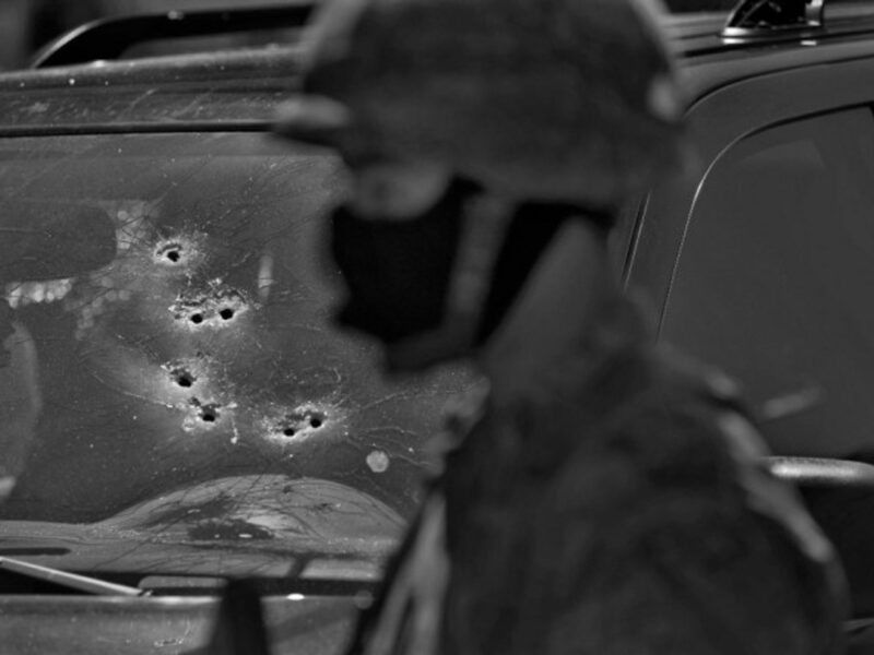 A Mexican soldier is standing before a vehicle in which two men were executed by drug cartel members in Sinaloa, Mexico, 2012.