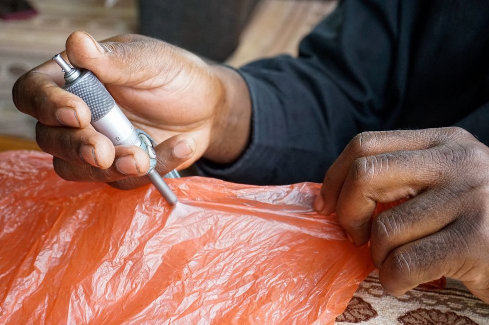 A micrometer is used to measure the thickness of plastic bags. Despite Zimbabwe’s ban on plastic thinner than 30 microns to cut waste and boost recycling, much of the plastic packaging at Mbare marketplace, a key trading center, is only 20 microns thick.