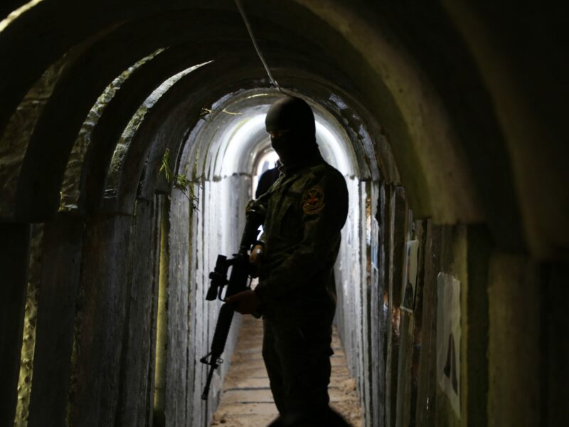 A militant stands in a dark underground tunnel
