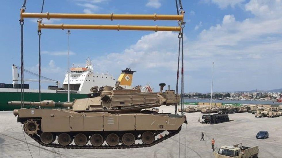 A military tank is being unloaded in the port.