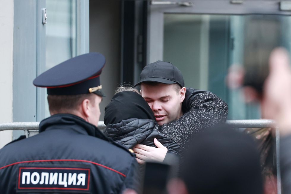 A mobilized man says goodbye to his family at a temporary mobilization station