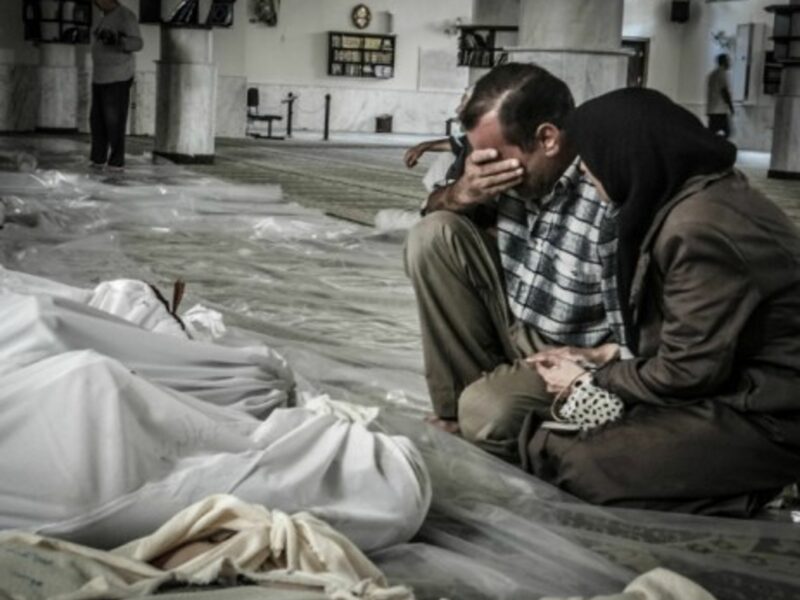 A mother and father weep over the body of their child, killed in a suspected chemical weapons attack on Damascus