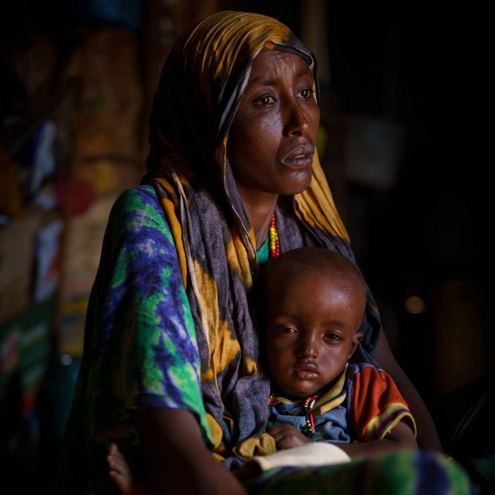 A mother with her infant inside a village hut at Yaa Galbo, Marsabit County, Kenya.