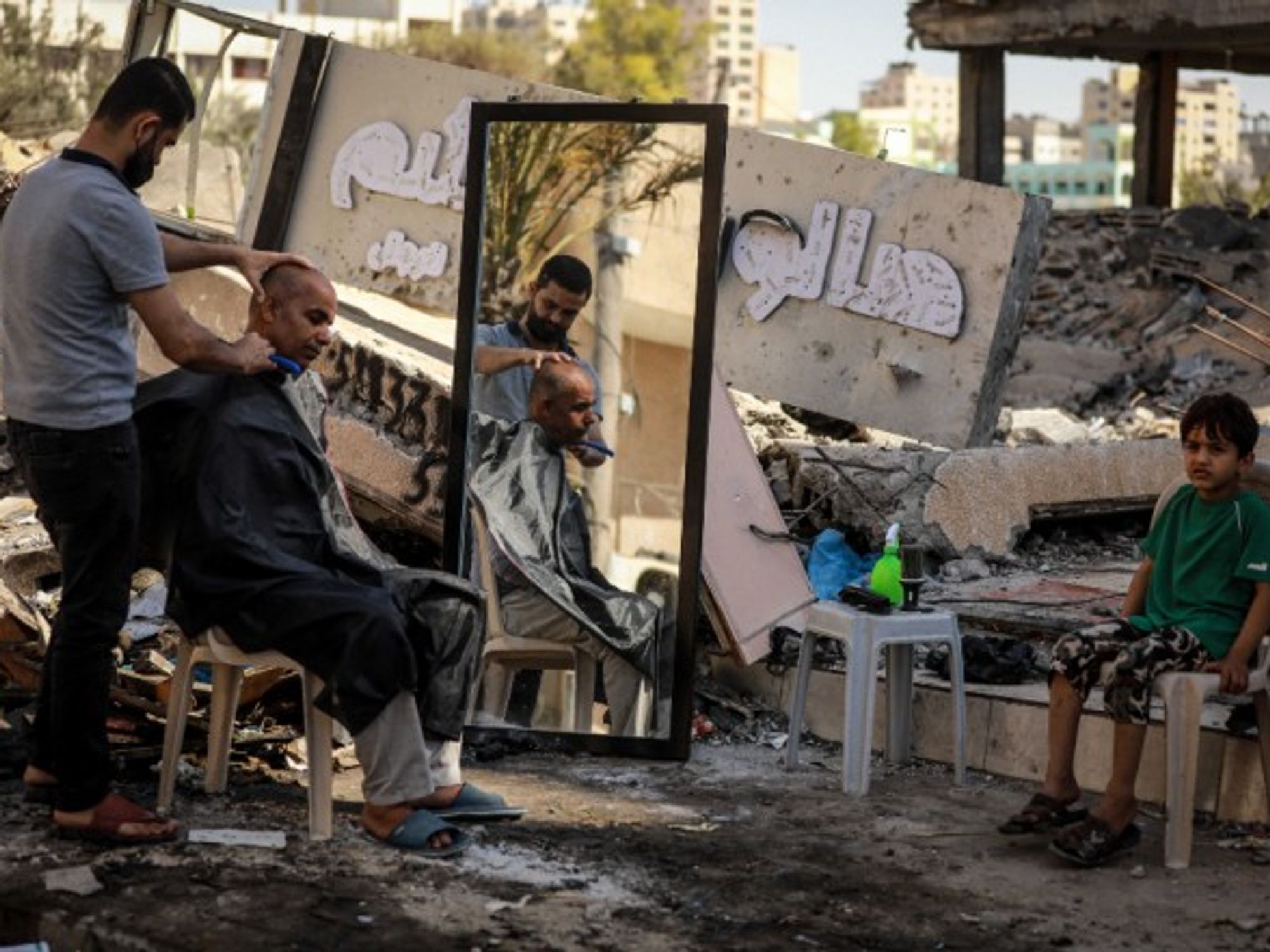 A Palestinian barber works among ruins of buildings and shops in Gaza City, on May 25