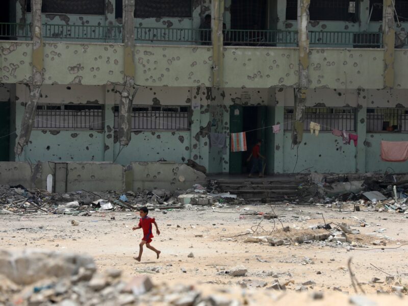 A Palestinian child runs along a devastated street in Khan Yunis.