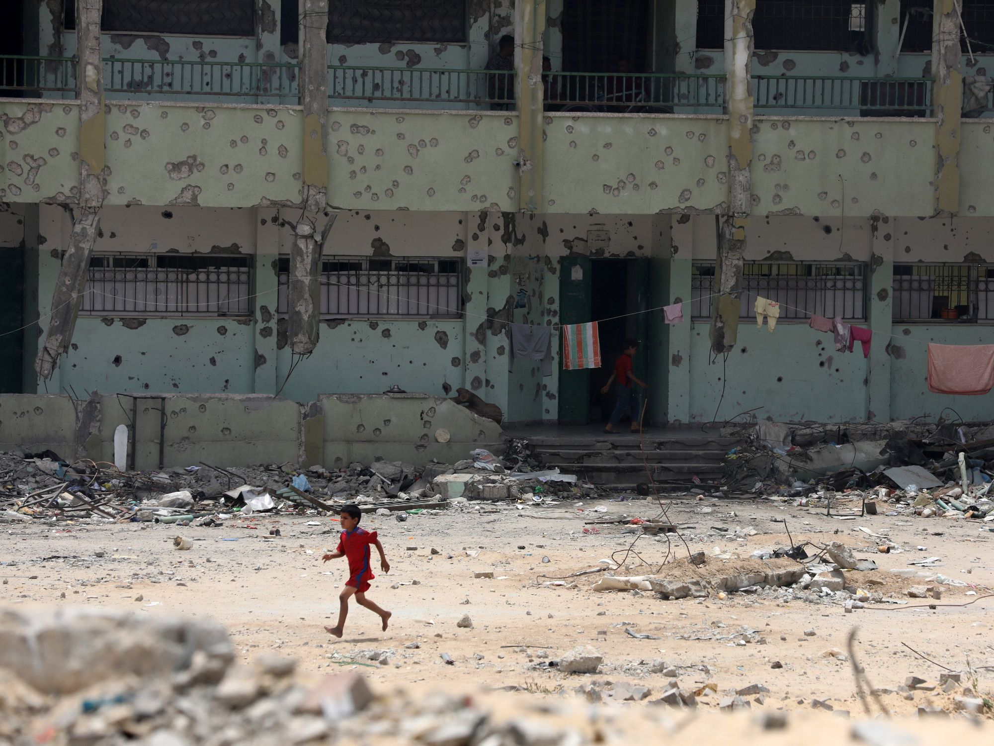 A Palestinian child runs along a devastated street in Khan Yunis.