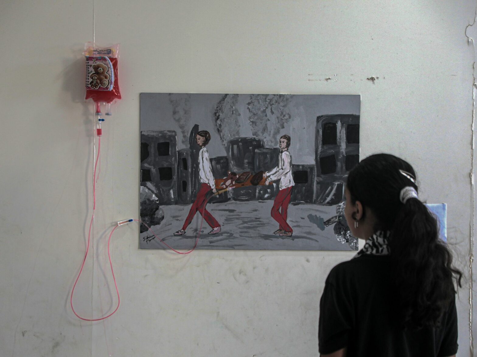 A Palestinian girl views an artwork at a World Mental Health Day exhibition in the southern Gaza Strip city of Khan Younis, on Oct. 10, 2024.