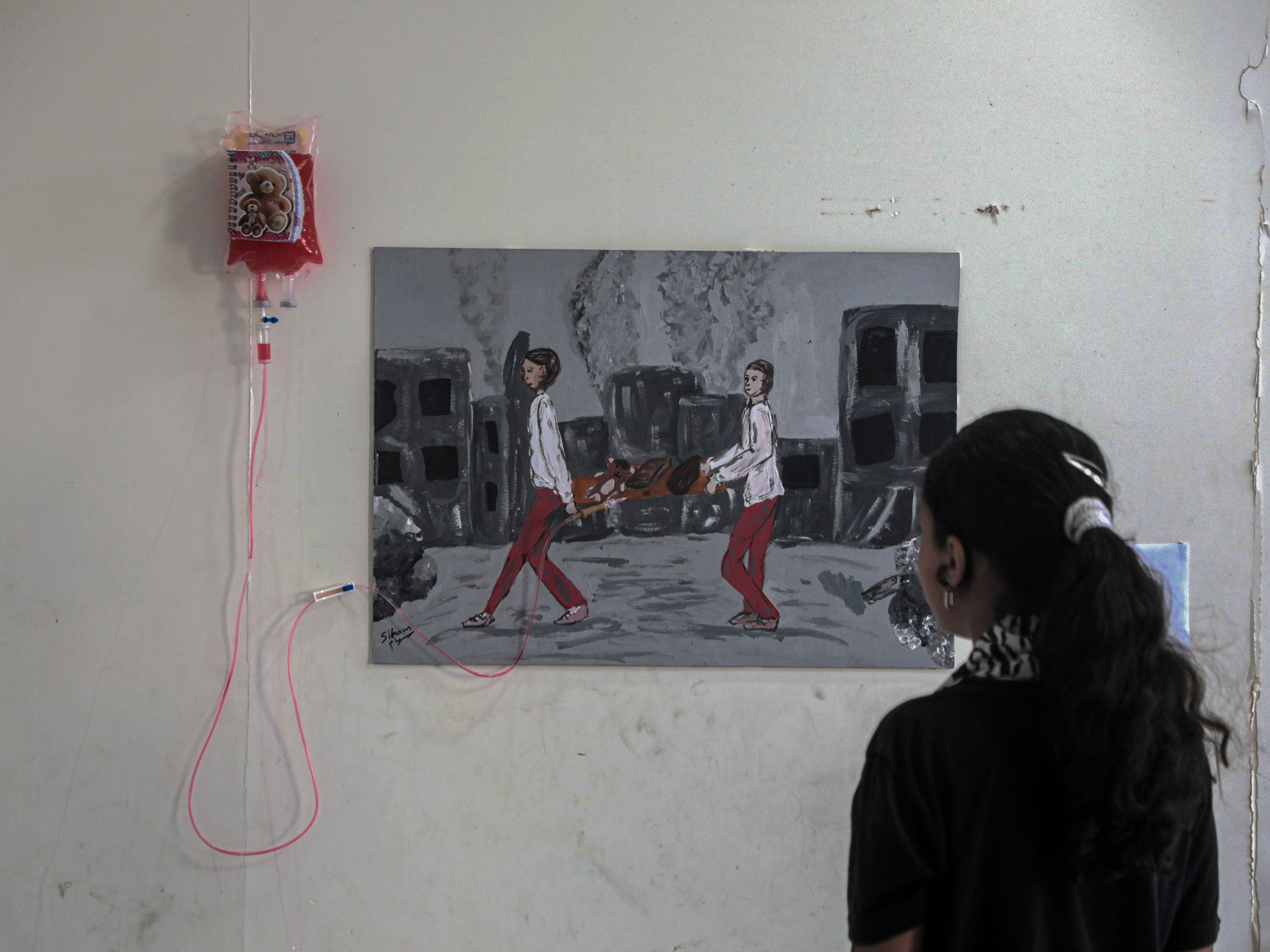 A Palestinian girl views an artwork at a World Mental Health Day exhibition in the southern Gaza Strip city of Khan Younis, on Oct. 10, 2024.