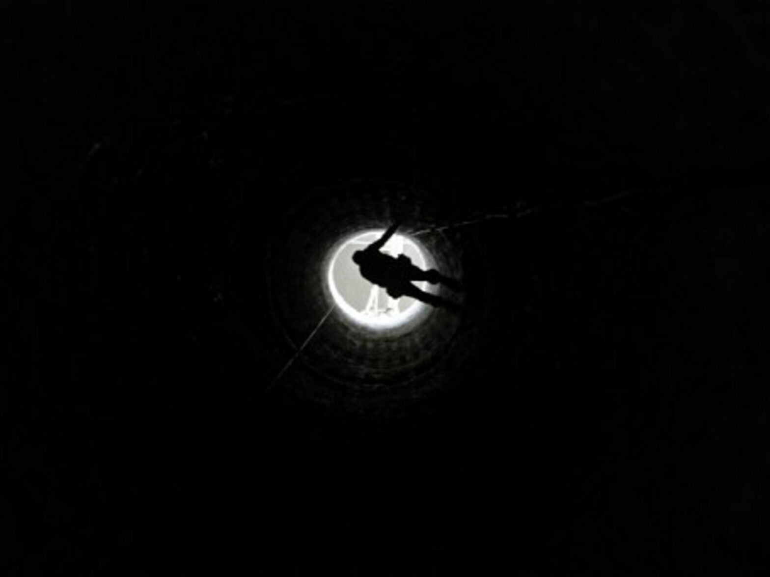 A Palestinian man in Rafah is lowered into a smuggling tunnel which connects Gaza and Egypt
