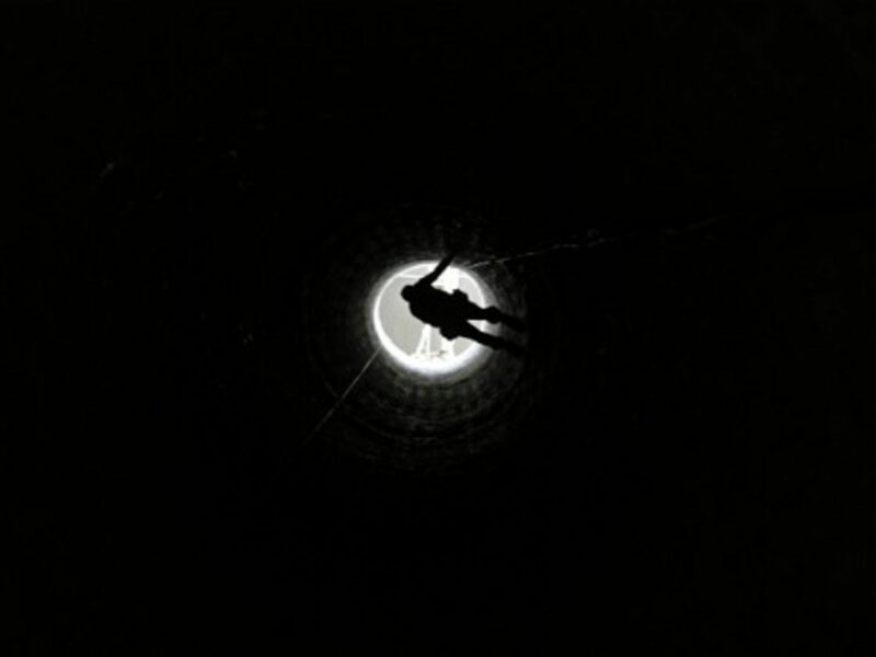 A Palestinian man in Rafah is lowered into a smuggling tunnel which connects Gaza and Egypt