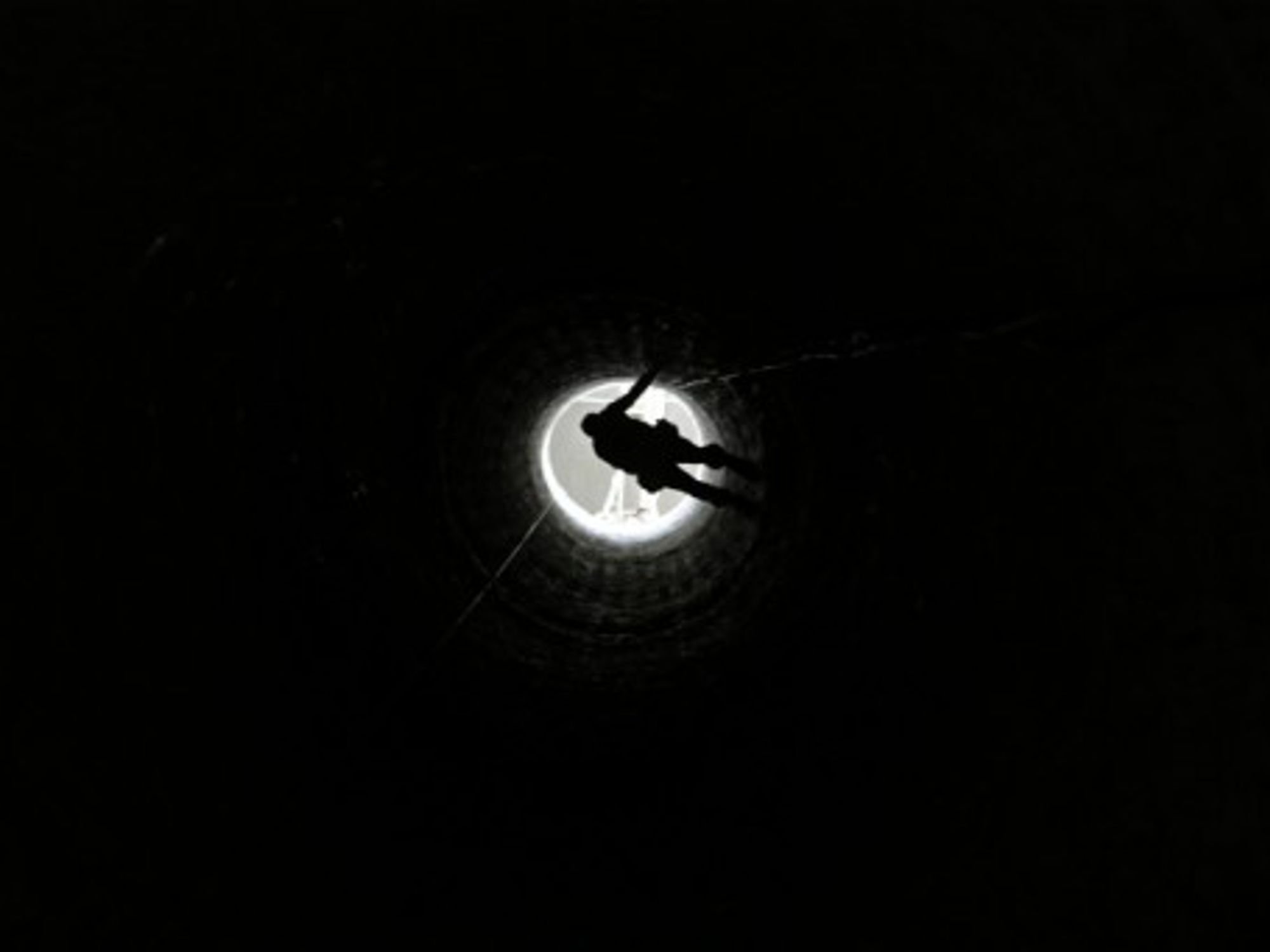 A Palestinian man in Rafah is lowered into a smuggling tunnel which connects Gaza and Egypt