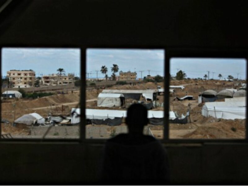 A Palestinian man looks on as an Egyptian military operation takes place in Rafah, Egypt.