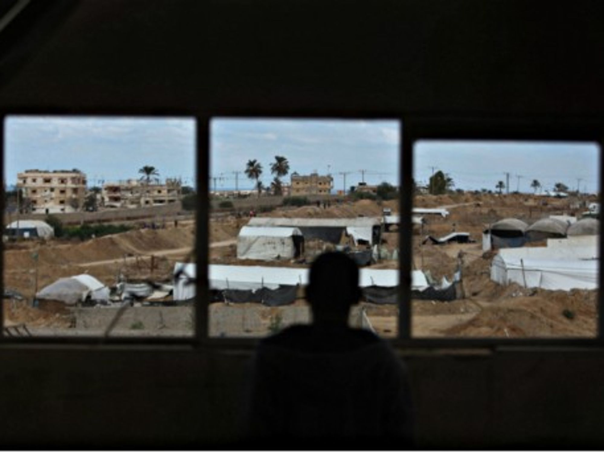 A Palestinian man looks on as an Egyptian military operation takes place in Rafah, Egypt.