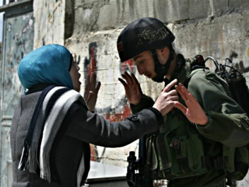 A Palestinian woman argues with an Israeli soldier in the West Bank village of Awarta