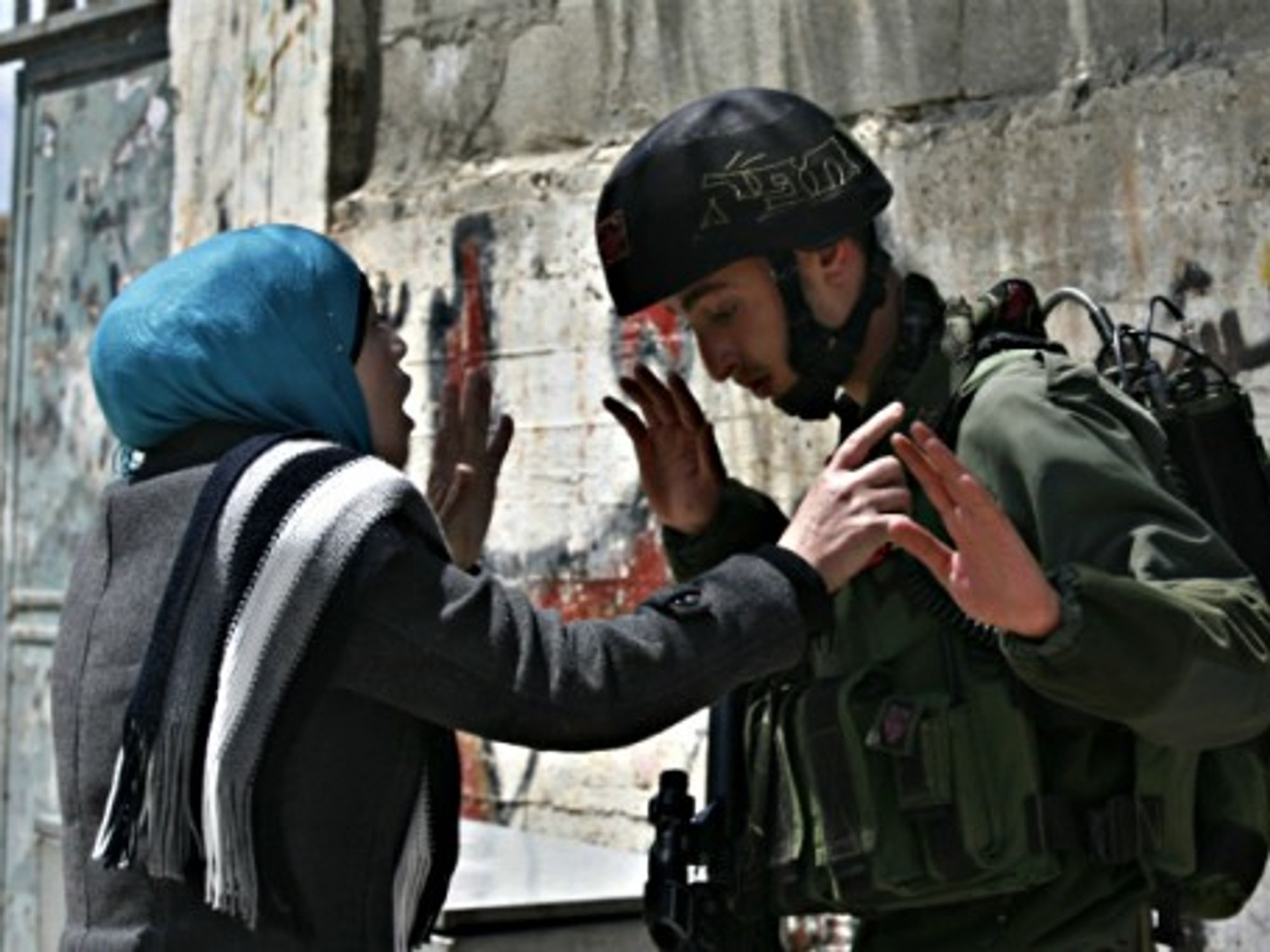 A Palestinian woman argues with an Israeli soldier in the West Bank village of Awarta