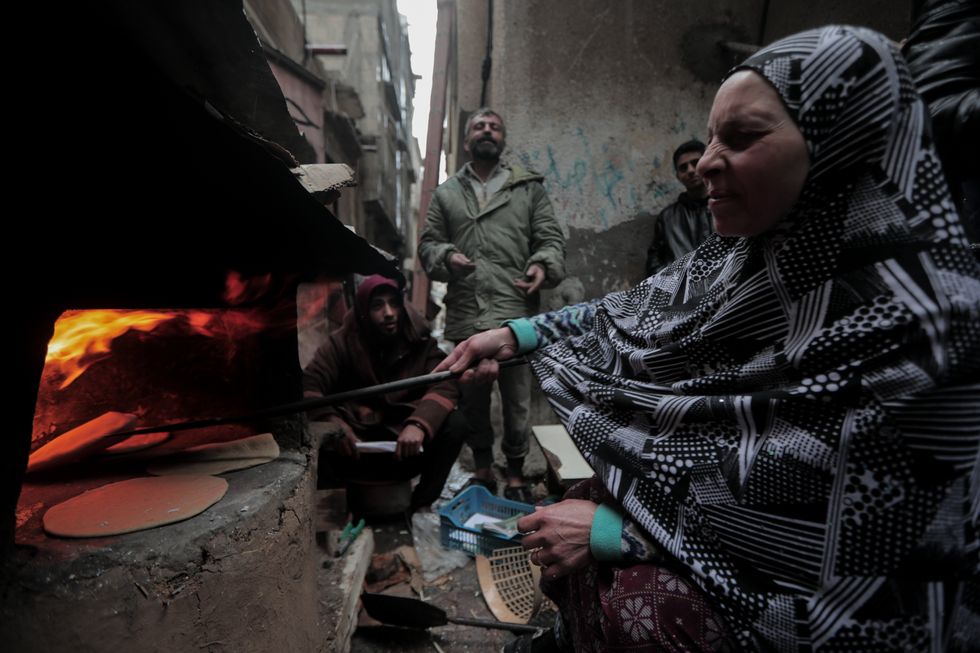 A Palestinian woman makes bread in an old oven in the Al-Maghazi refugee camp in the central Gaza Strip.
