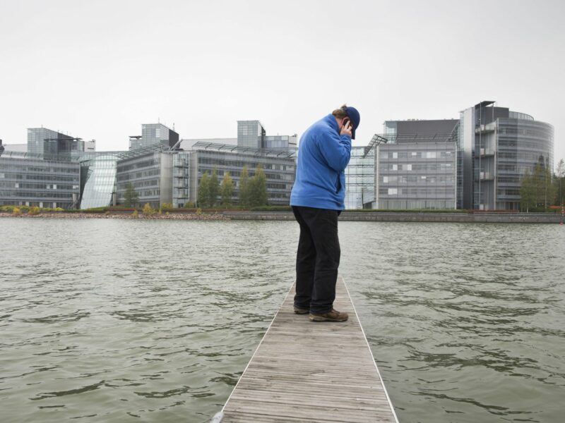 A person on the phone standing near the HQ of Nokia in Espoo, Finland