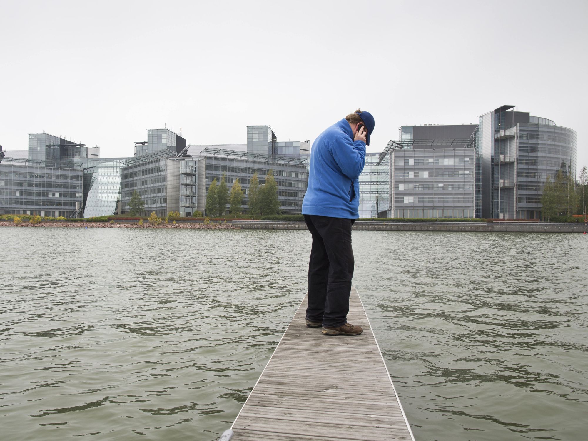 A person on the phone standing near the HQ of Nokia in Espoo, Finland
