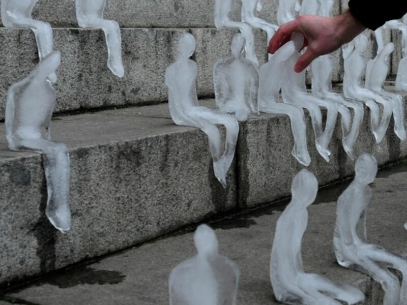 A person touches one of the human figures elaborated with ice in Santiago, Chile.