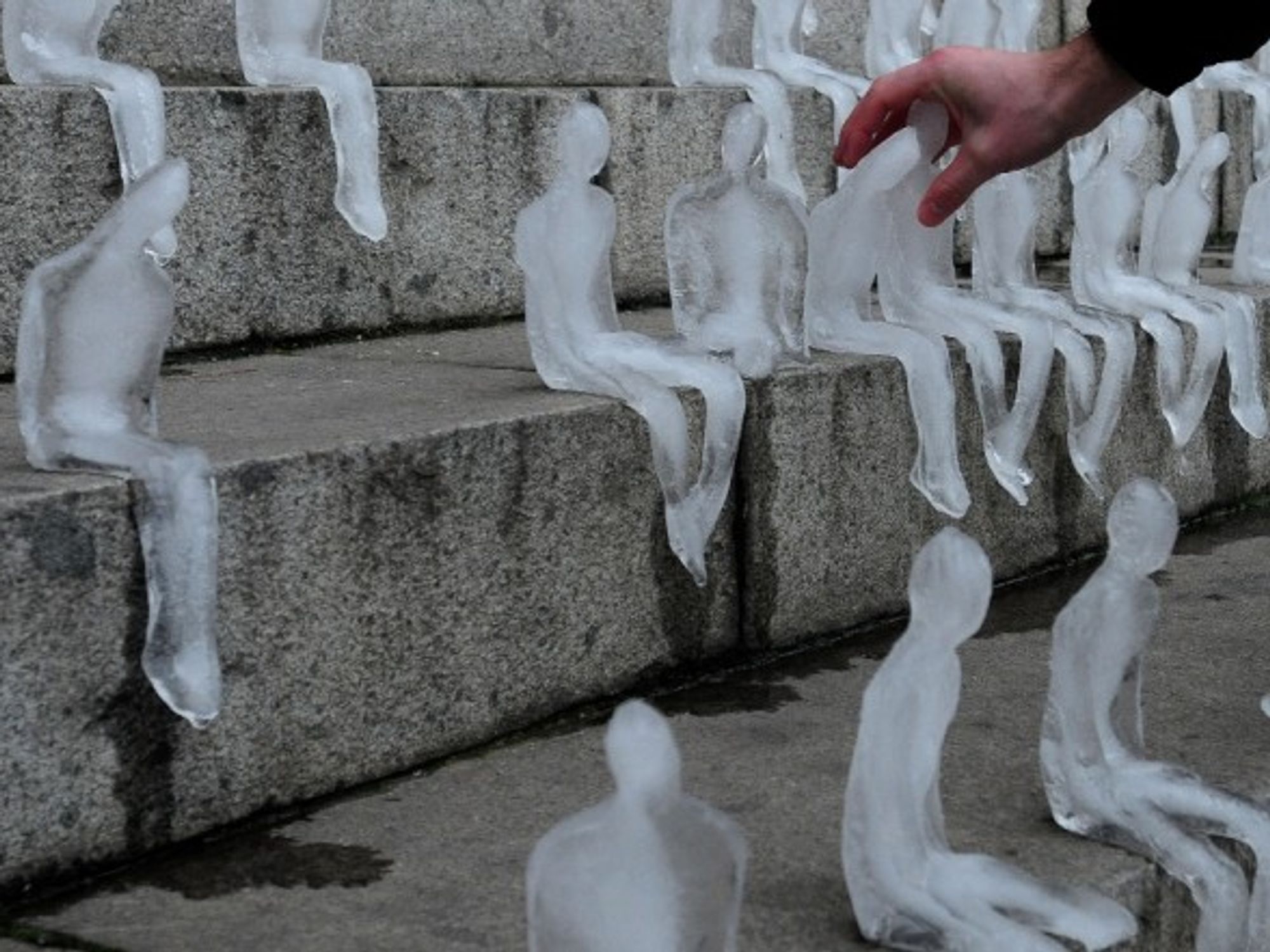 A person touches one of the human figures elaborated with ice in Santiago, Chile.