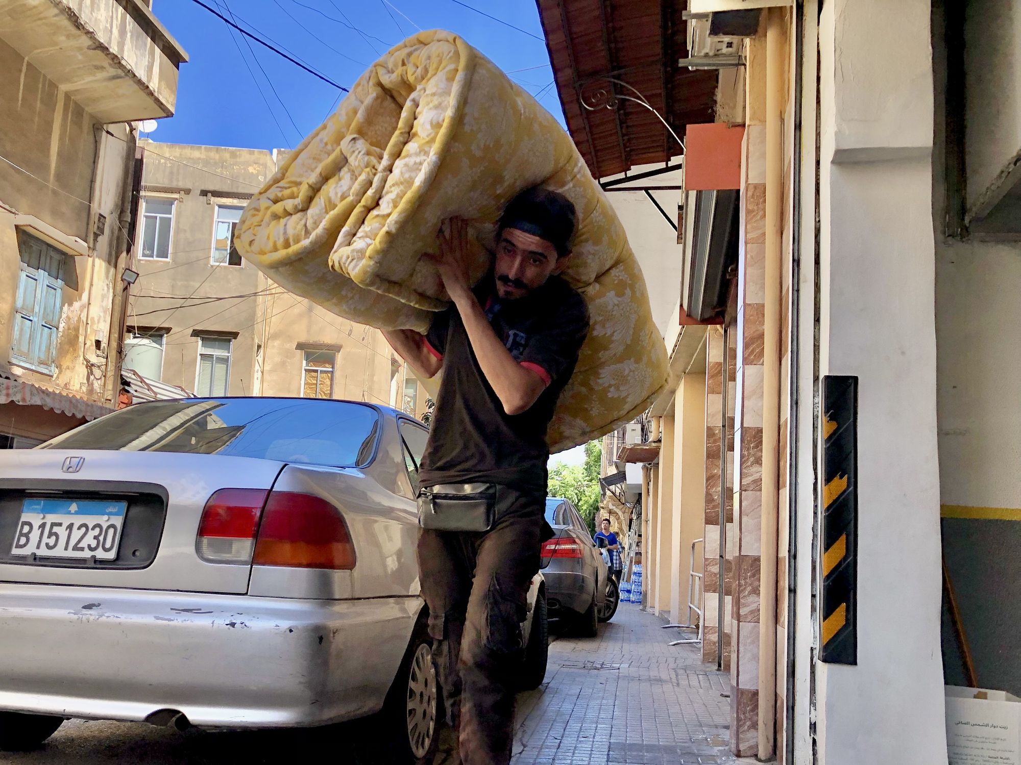 A photo of a man carrying a mattress for displaced people in Beirut, Lebanon, on Sept. 23, 2024.