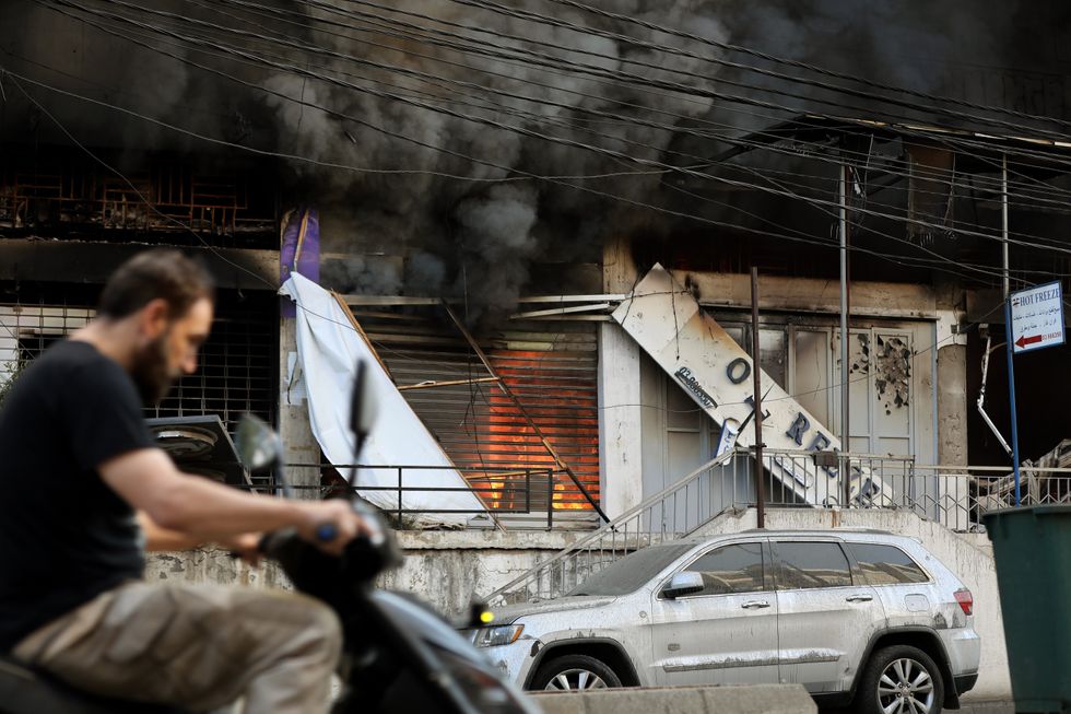 A photo of a motorist drive past a building that was targeted by Israeli air raids at old Beirut airport road on the edge of Beirut southern suburb