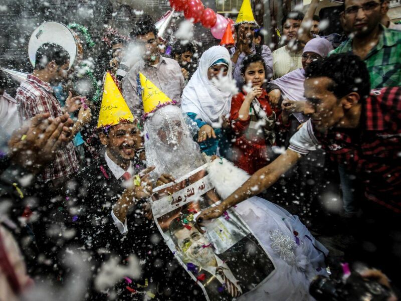 a photo of bride and groom holding a poster of Egypt's ousted President Mohamed Morsi during their wedding in Cairo