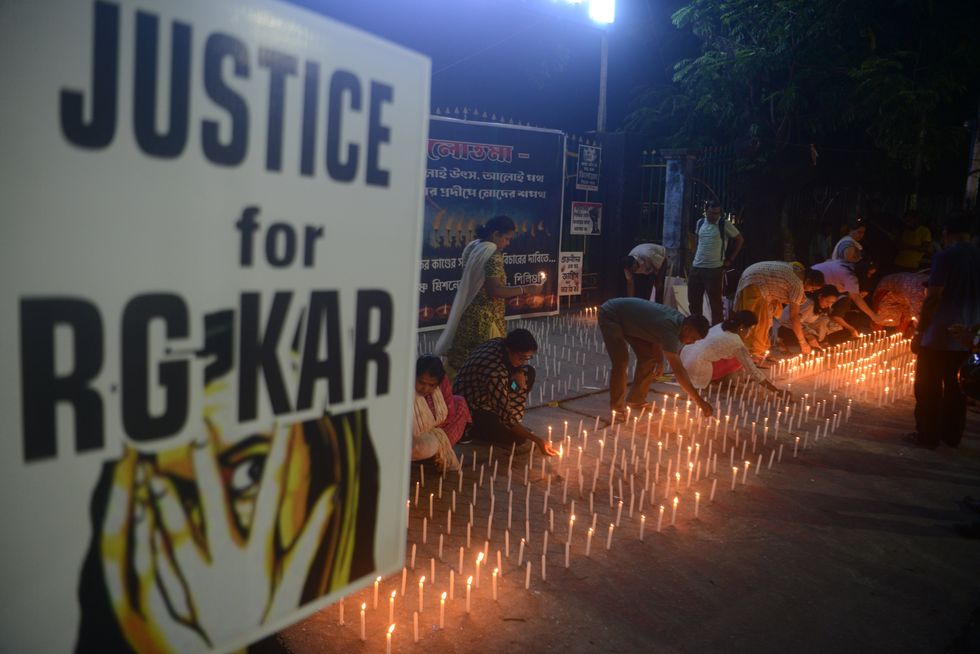 A photo of Ex students of Ramkrishna Mission lights candles as they take part in a protest to condemn the rape and murder of a young medic at RG Kar Medical college and hospital at Kolkata in Siliguri.