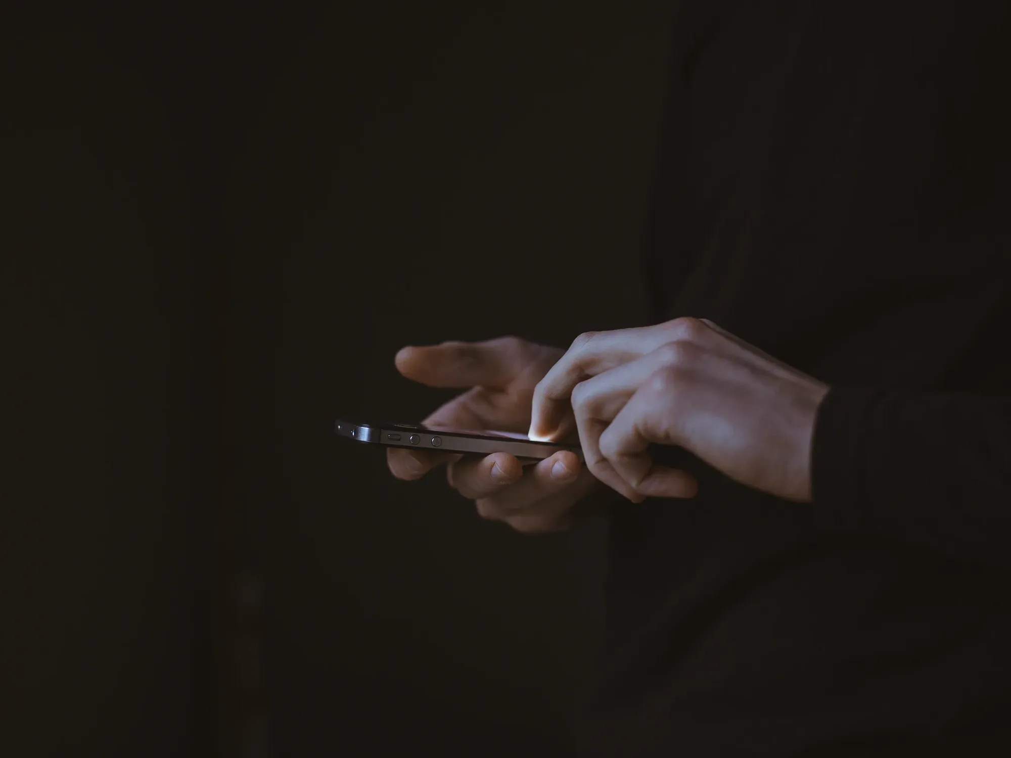 A photo of hands holding onto a smartphone