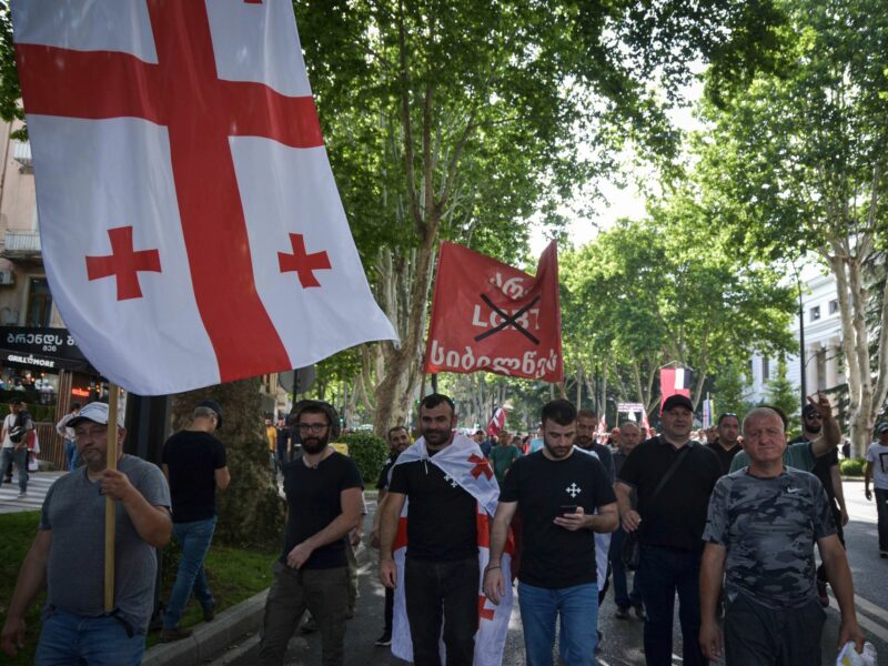 A photo of Homophobic protesters marching across Tbilisi's streets, during a demonstration against LGBTQ+ pride.