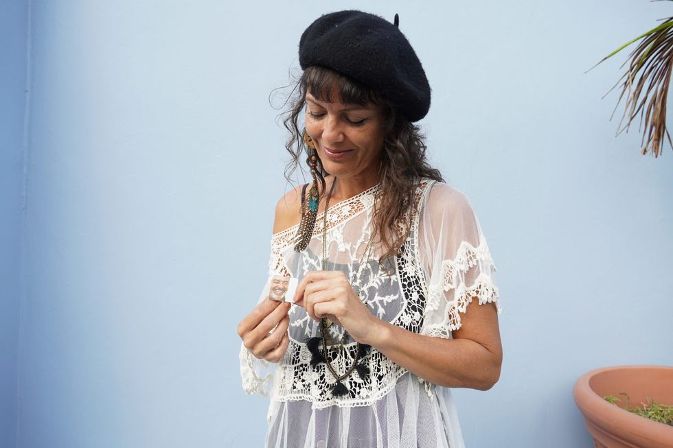 A photo of Jessica Rodríguez posing with a photo of her father, Víctor Antonio Rodríguez Deynes, in San Juan, Puerto Rico.