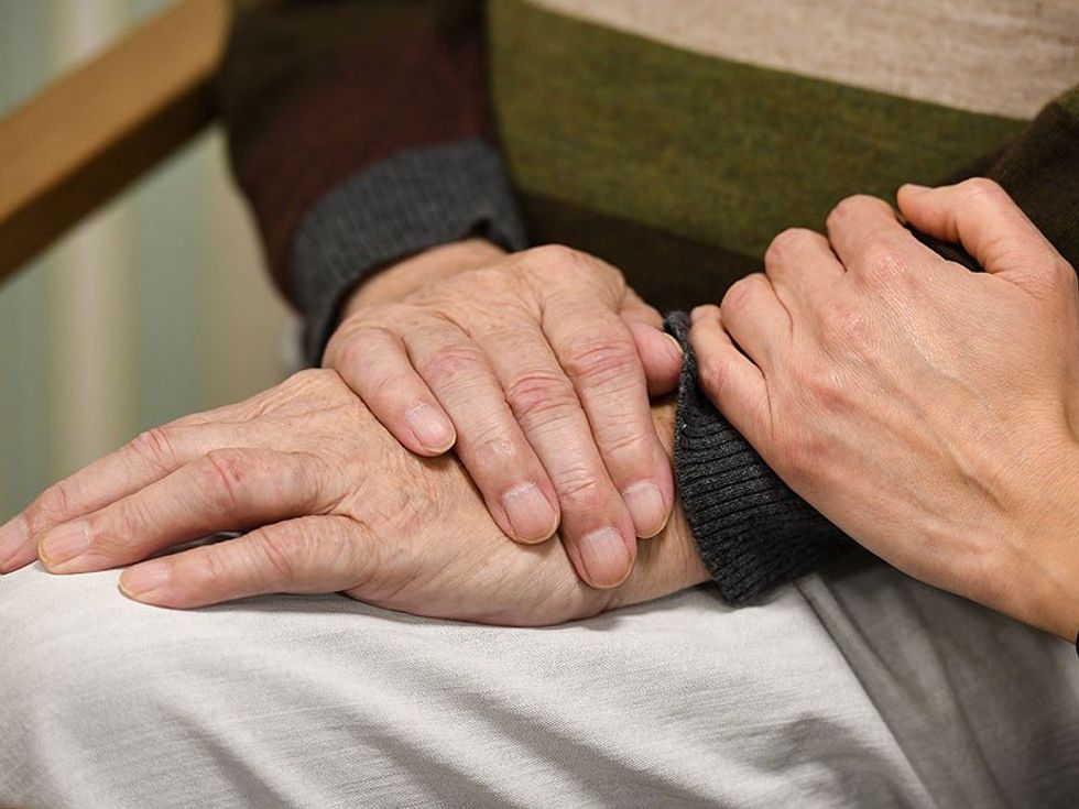 A photo of old people holding hands