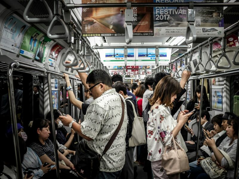 A photo of people on a crowded- bus using social media