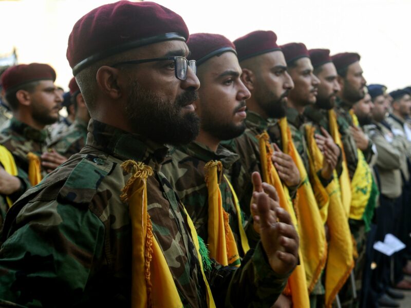 A photo of Pro-Iranian Hezbollah fighters beat on their chests as a sign or mourning during a ceremony to mark the 40th day of the assassination