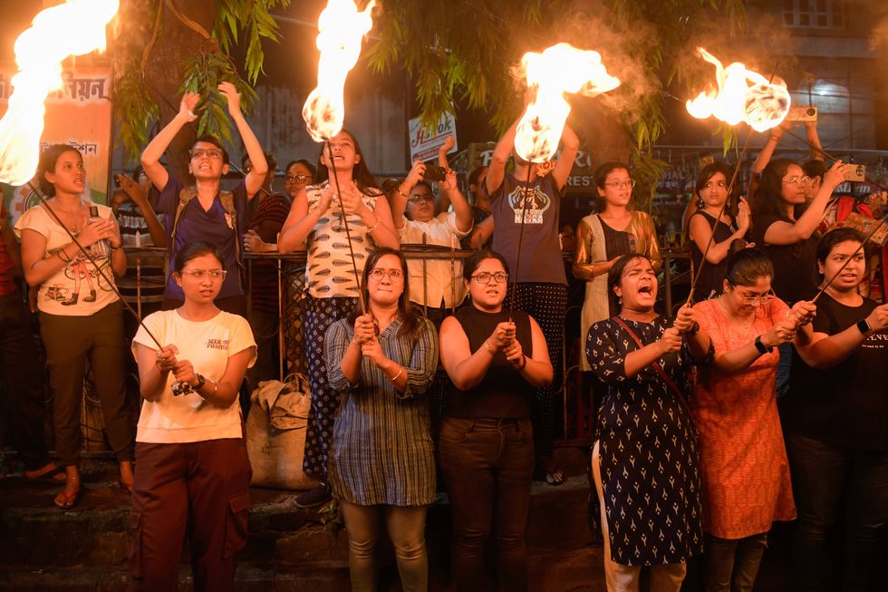 A photo of Women holding lit torches as they take part in a vigil named 'Reclaim the Night'. Thousands of people in different parts of Kolkata took part in a vigil named Reclaim the Night condemning the rape and murder of a trainee medic at a West Bengal state government-run hospital in Kolkata, India.