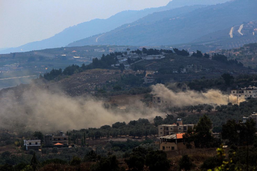 A photo ofHeavy white smoke billows from between houses of the southern Lebanese village of Kfar Kila following heavy Israeli shelling.
