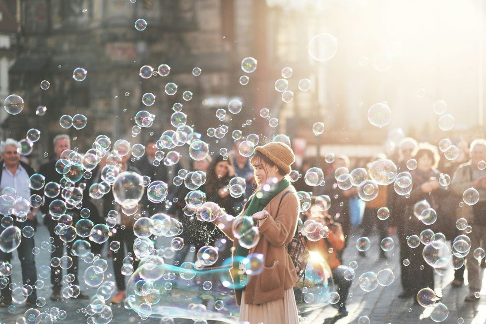 A photograph of a woman surrounded by bubbles in Prague.