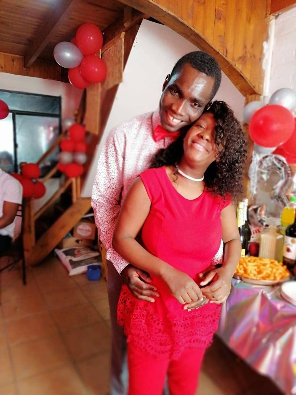 A photograph of Herby and Shella smiling at the camera at a party