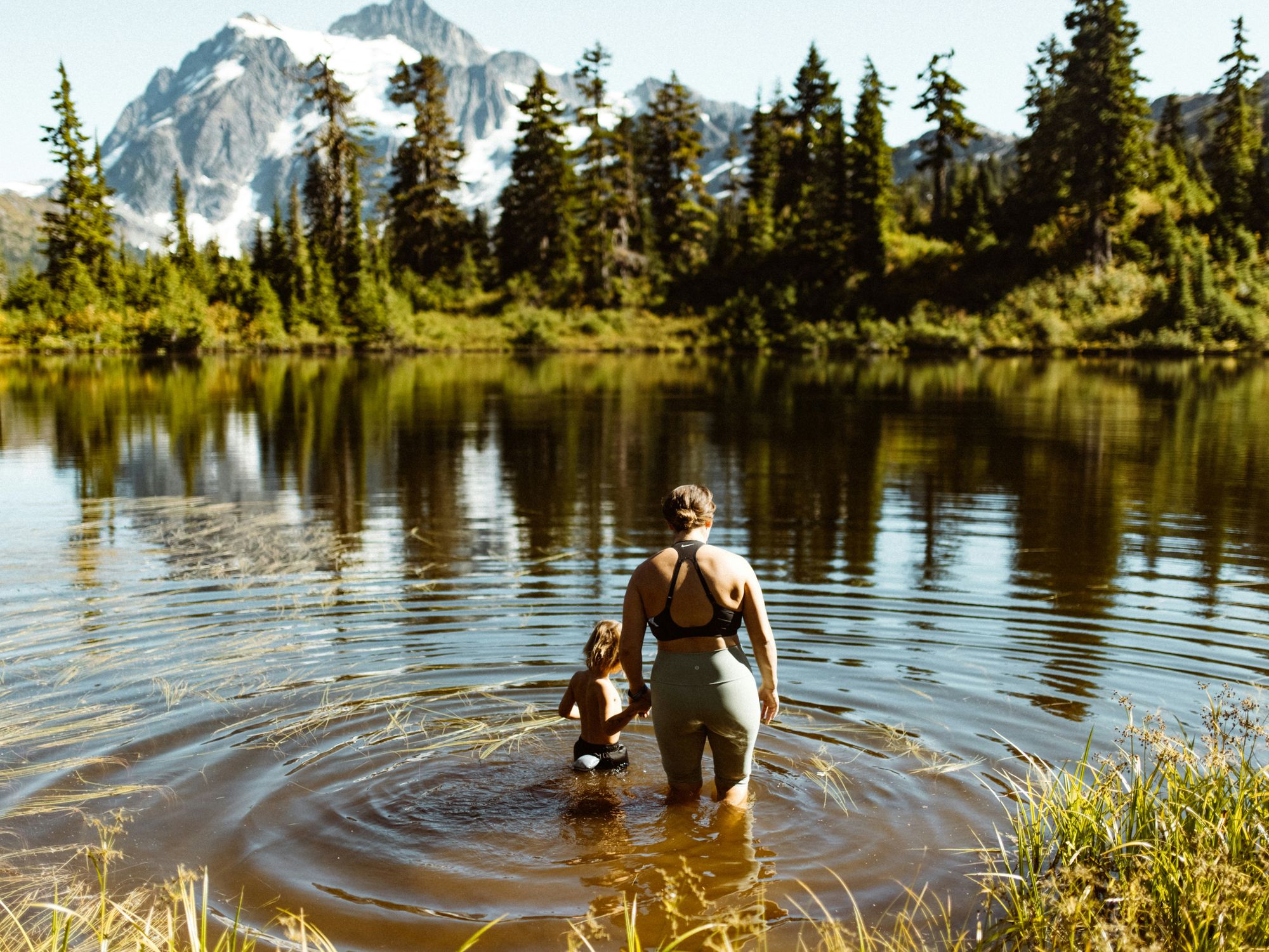 A picture of a mother and her child in a lake.