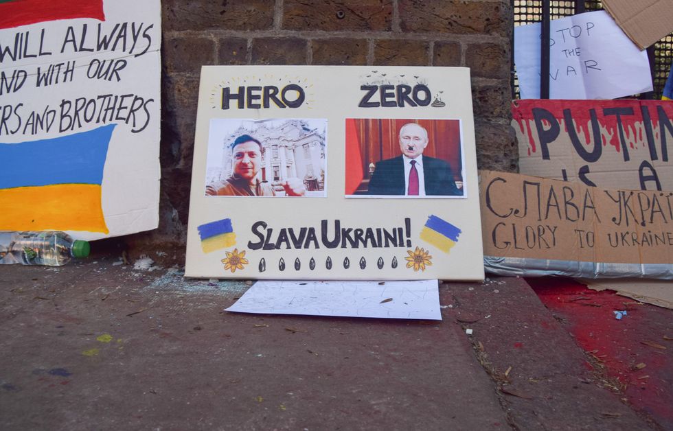 A placard depicts Volodymyr Zelensky as a "hero" and Vladimir Putin as "zero".