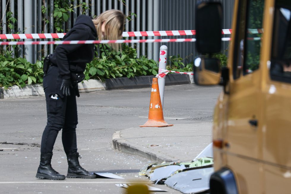 A police officer examines fragments of the drone that hit an apartment block in southwestern Moscow.