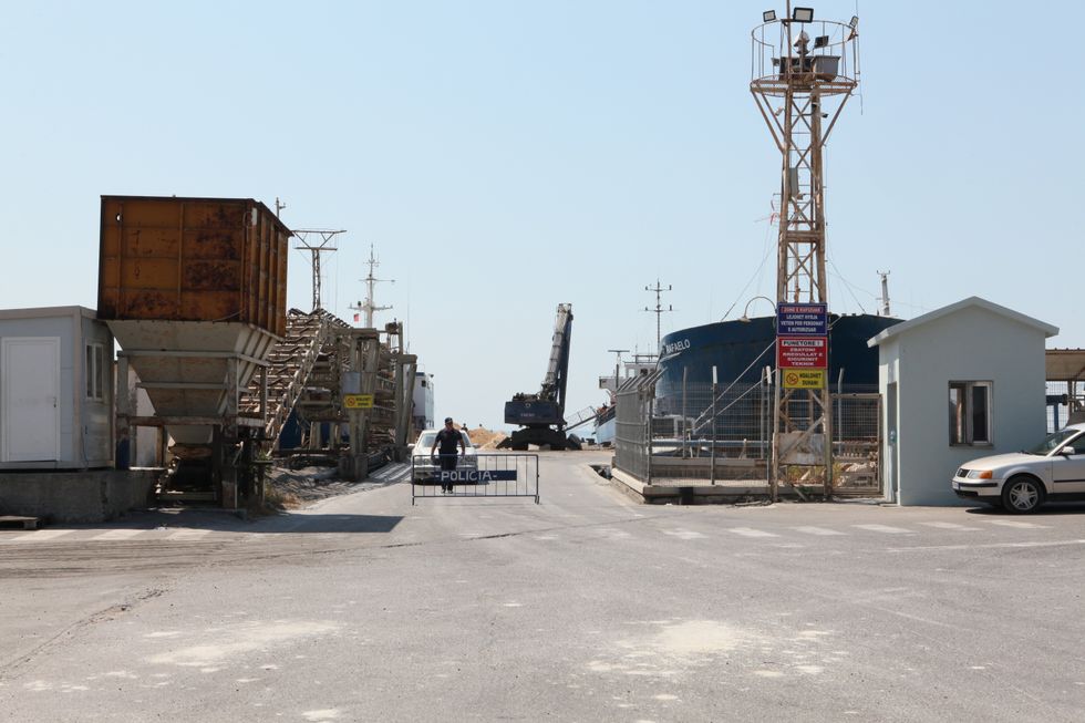 A police officer stands at a checkpoint at the port of Shengjin in northern Albania. Italy is currently building a large reception camp for Mediterranean refugees in Gjader,