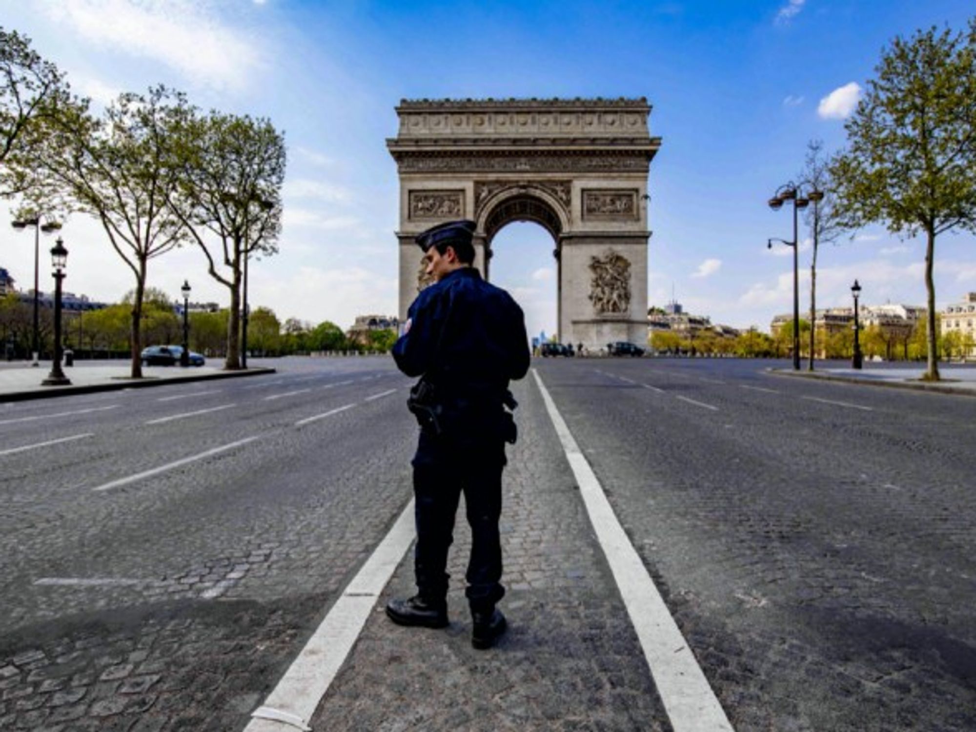 A police officer stands in front of the Arc de Triomphe during the coronavirus lockdown in Paris, France.