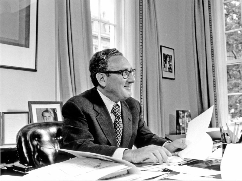 A portrait of Doctor Henry A. Kissinger behind a desk in Washington, D.C