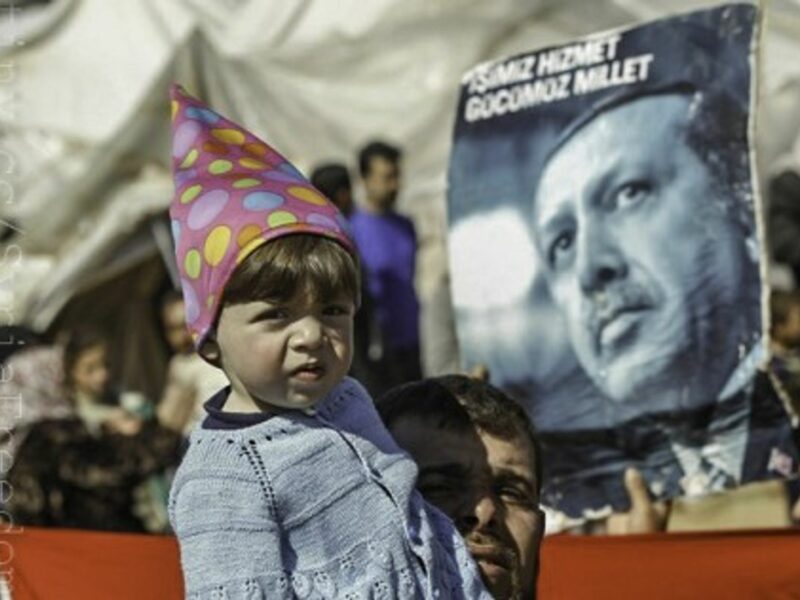 A portrait of Turkish PM Tayyip Erdogan behind a Syrian girl in a refugee camp on the Turkish-Syrian border (FreedomHouse2)