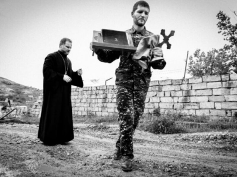 A priest and a soldier getting ready for mass in Talish