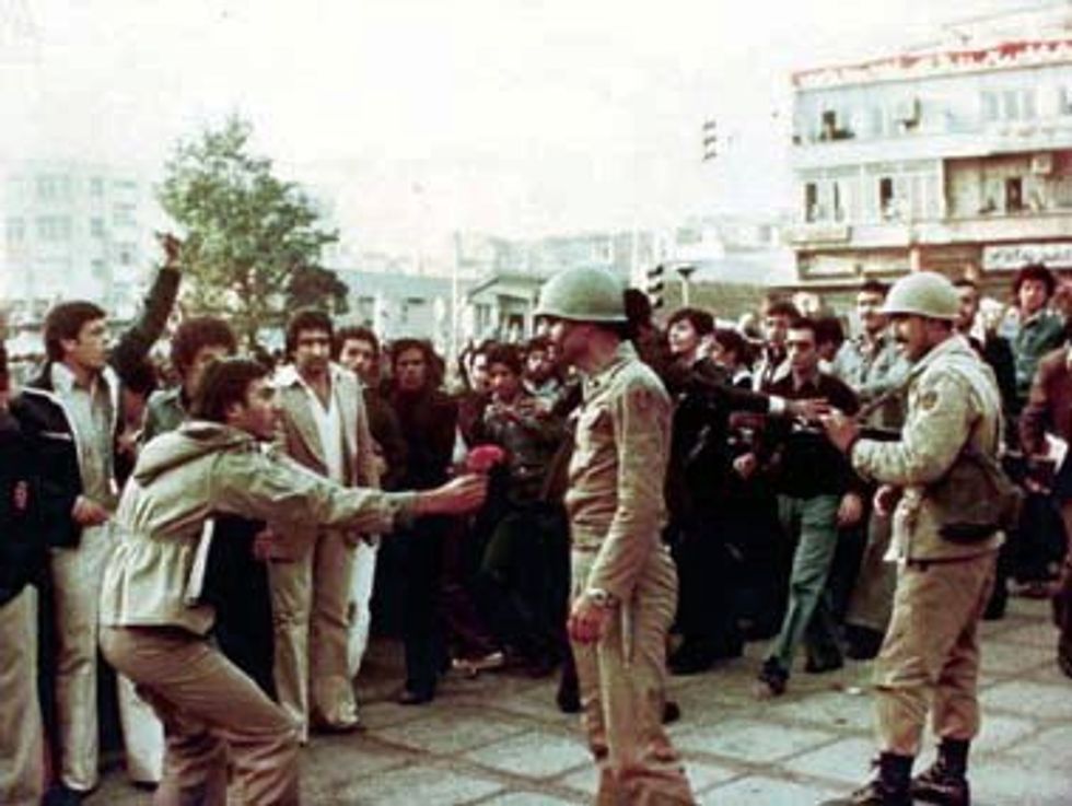 A protester giving flowers to an army officer.