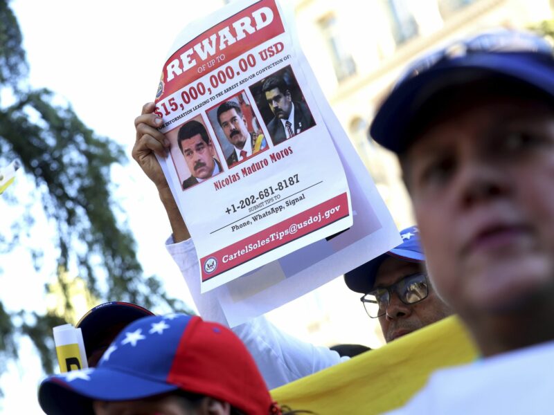A protester holds a reward sign for Maduro