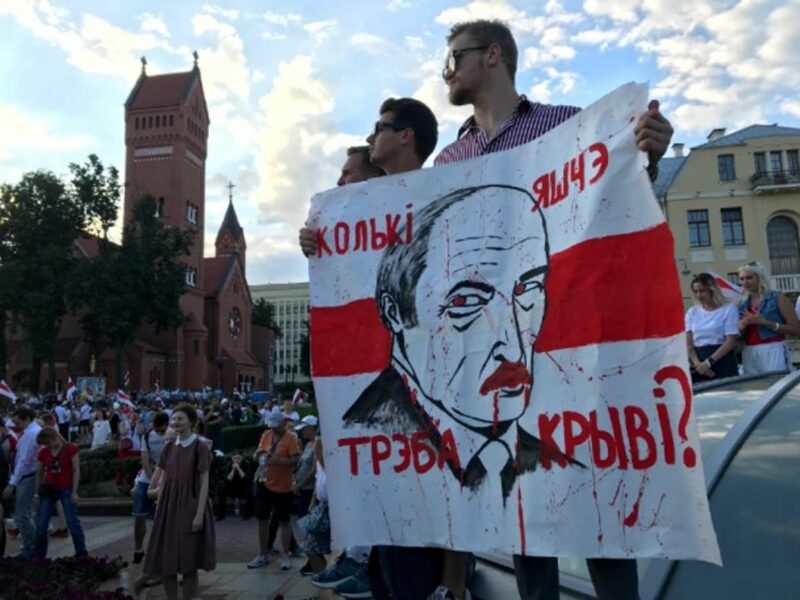 A protester holds up a sign that reads 'How much more blood will it take?' in Independence Square in Minsk, Belarus.